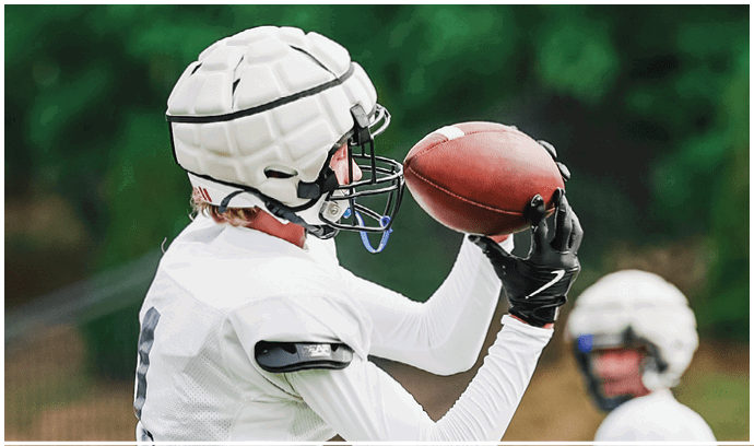A football player is sliding on the ground. Description generated by AI