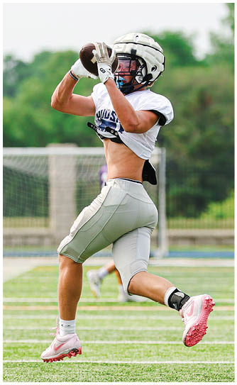 A football player catching a ball. Description generated by AI