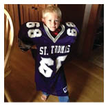 Two football players wearing black jerseys and holding hands. Description generated by AI