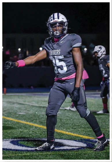 Two football players wearing black jerseys and holding hands. Description generated by AI