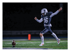 Two football players wearing black jerseys and holding hands. Description generated by AI
