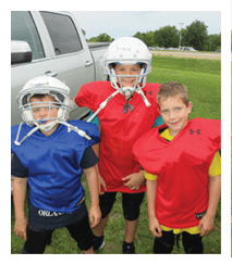 Two football players wearing black jerseys and holding hands. Description generated by AI