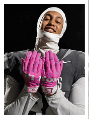 Two football players wearing black jerseys and holding hands. Description generated by AI