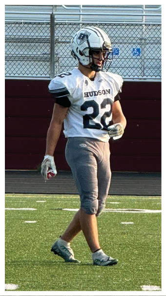 Two football players wearing black jerseys and holding hands. Description generated by AI