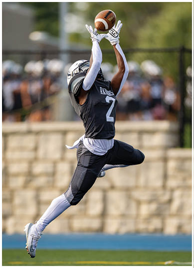 A football player wearing a blue and red jersey. Description generated by AI