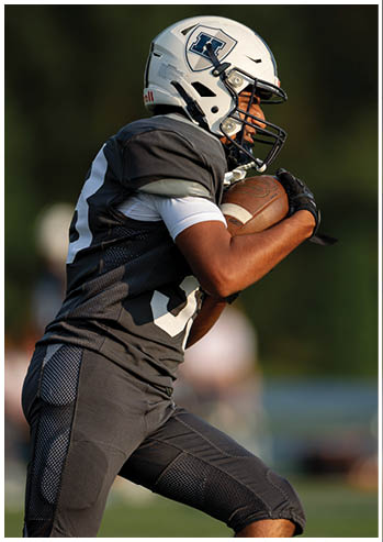 A football player running on the field. Description generated by AI