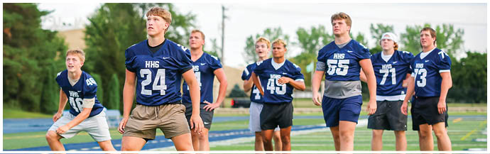 A group of football players on a field. Description generated by AI