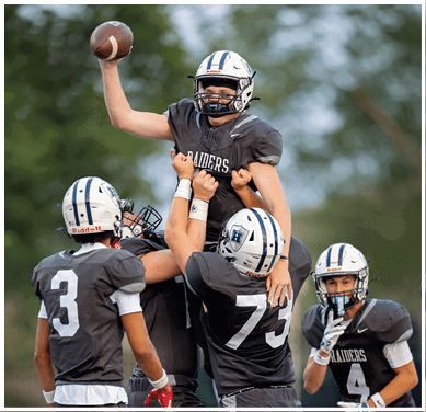 A football game is taking place with a group of men on the field. Description generated by AI