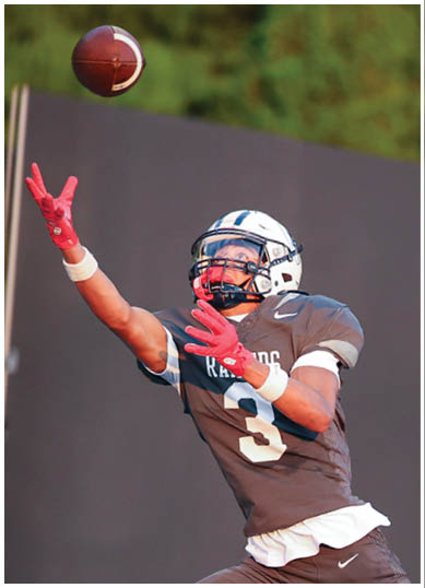 A football player wearing a blue and red jersey. Description generated by AI