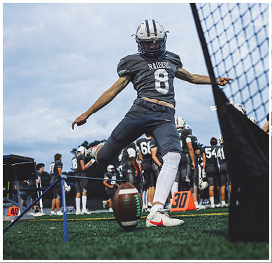 A football game is taking place with a group of men on the field. Description generated by AI
