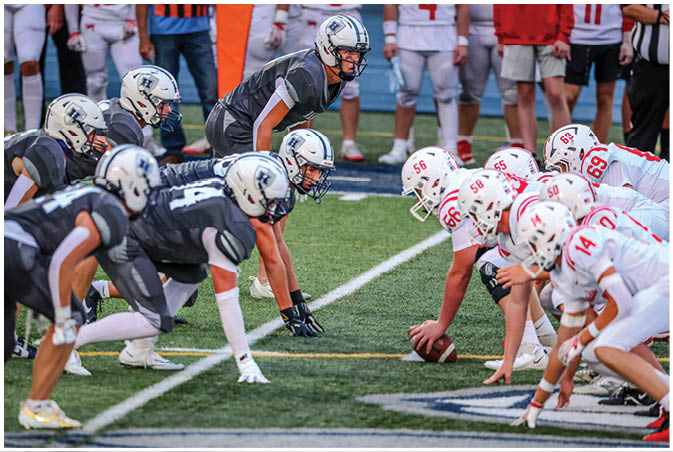 A group of football players wearing black and white uniforms. Description generated by AI