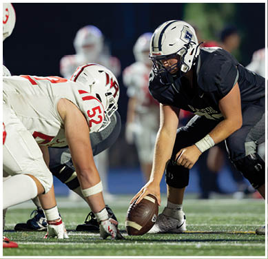 A football game is taking place with a group of men on the field. Description generated by AI