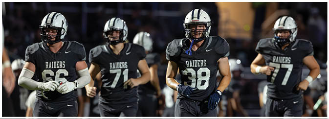 A group of football players on a field. Description generated by AI