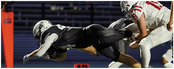 A football player is sliding on the ground. Description generated by AI