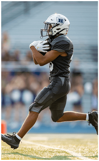 A football player catching a ball. Description generated by AI