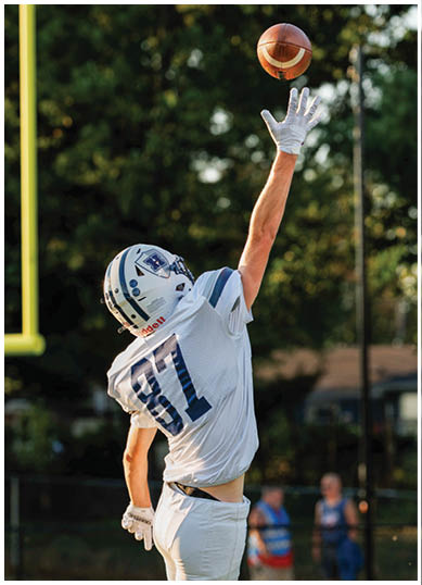 A football player wearing a blue and red jersey. Description generated by AI