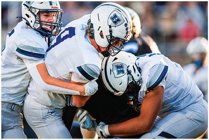 A group of football players wearing black and white uniforms. Description generated by AI