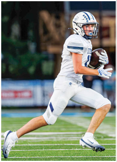A football player wearing a blue and red jersey. Description generated by AI