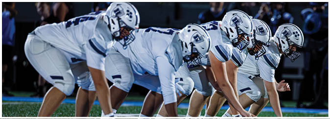 A group of football players on a field. Description generated by AI