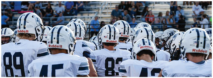 A football player wearing a blue and white uniform. Description generated by AI