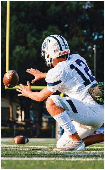 A football player catching a ball. Description generated by AI