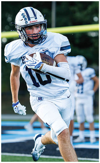 A football player catching a ball. Description generated by AI