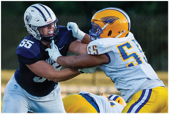 A group of football players wearing black and white uniforms. Description generated by AI