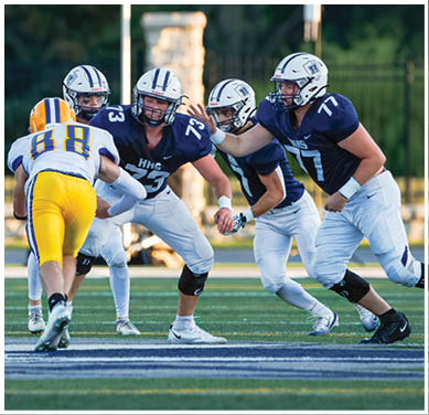 A football game is taking place with a group of men on the field. Description generated by AI