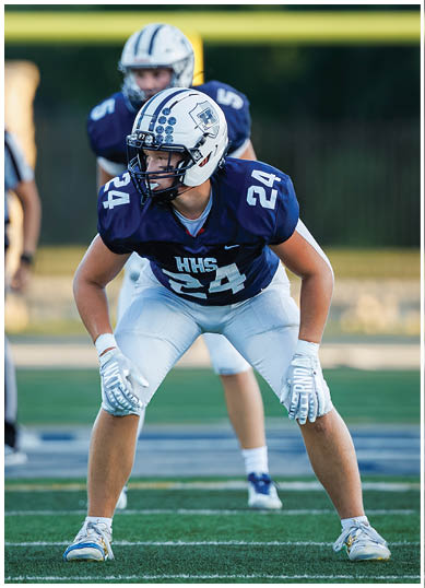 A football player wearing a blue and red jersey. Description generated by AI