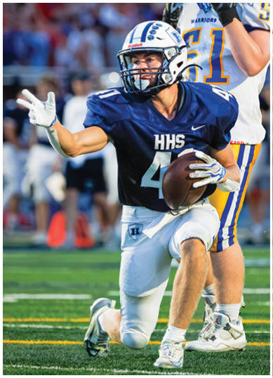 A football player wearing a blue and red jersey. Description generated by AI