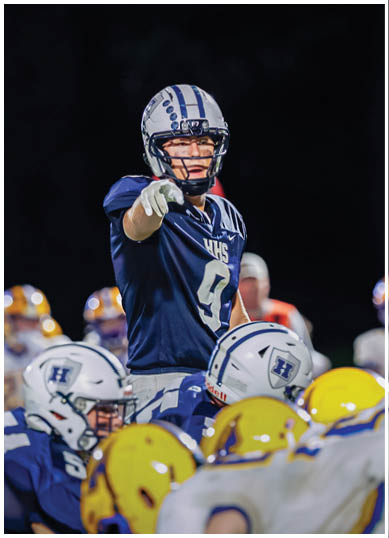 A football player wearing a blue and red jersey. Description generated by AI