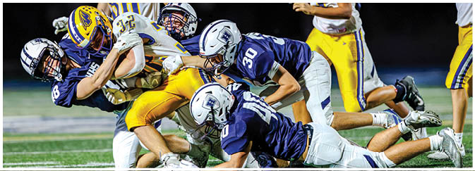 A group of football players on a field. Description generated by AI