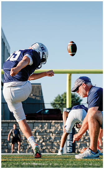 A football player catching a ball. Description generated by AI
