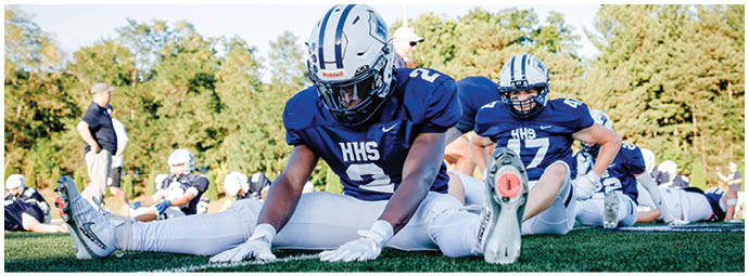 A football player wearing a blue and white uniform. Description generated by AI