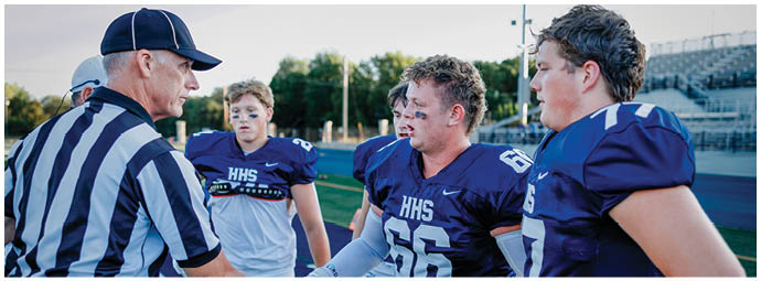 A football player wearing a blue and white uniform. Description generated by AI