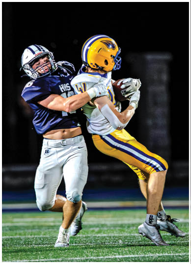 A football player wearing a blue and red jersey. Description generated by AI