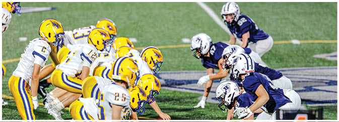 A group of football players on a field. Description generated by AI