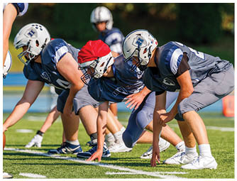 A group of football players on a field. Description generated by AI