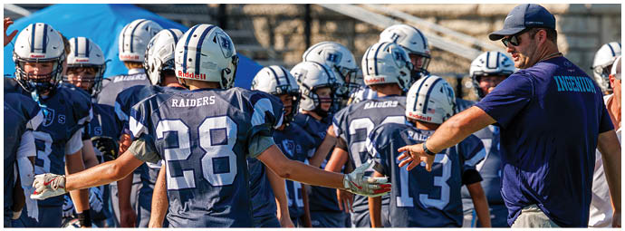 A football player wearing a blue and white uniform. Description generated by AI