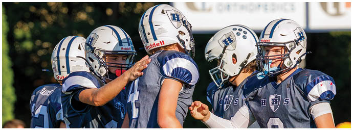 A football player wearing a blue and white uniform. Description generated by AI