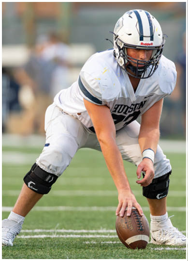 A football player wearing a blue and red jersey. Description generated by AI