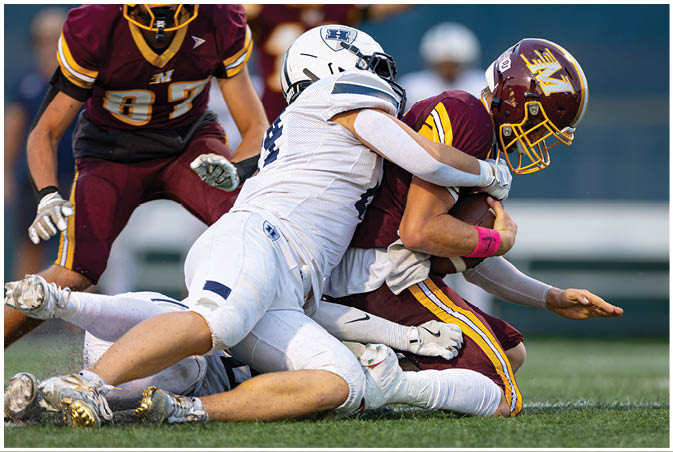A group of football players wearing black and white uniforms. Description generated by AI