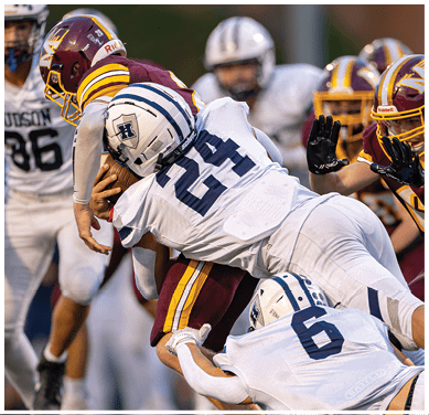 A football game is taking place with a group of men on the field. Description generated by AI