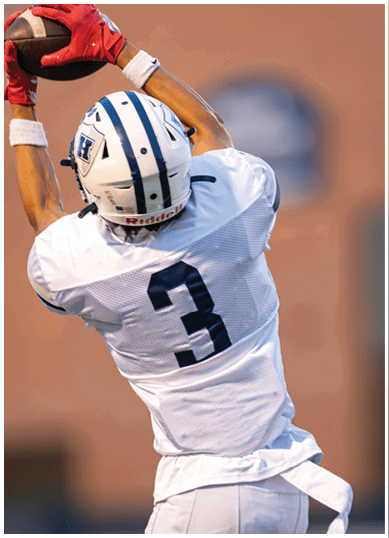 A football player wearing a blue and red jersey. Description generated by AI