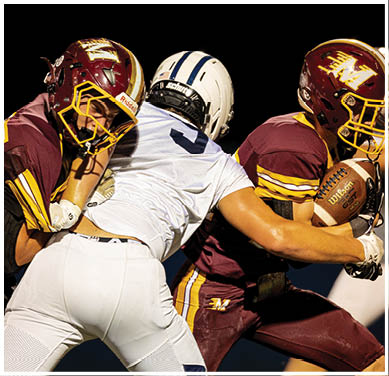 A football game is taking place with a group of men on the field. Description generated by AI