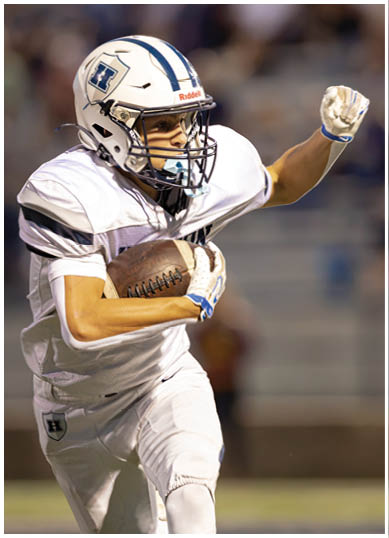 A football player wearing a blue and red jersey. Description generated by AI