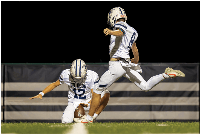 A group of football players wearing black and white uniforms. Description generated by AI