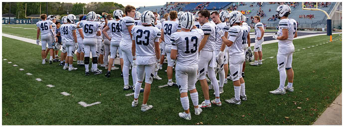 A football player wearing a blue and white uniform. Description generated by AI