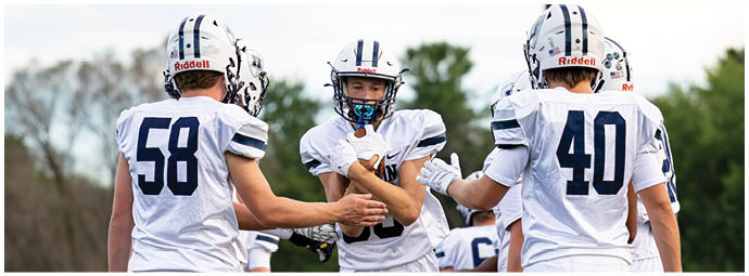 A football player wearing a blue and white uniform. Description generated by AI