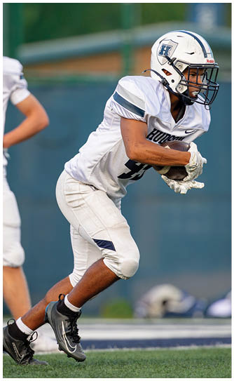 A football player catching a ball. Description generated by AI